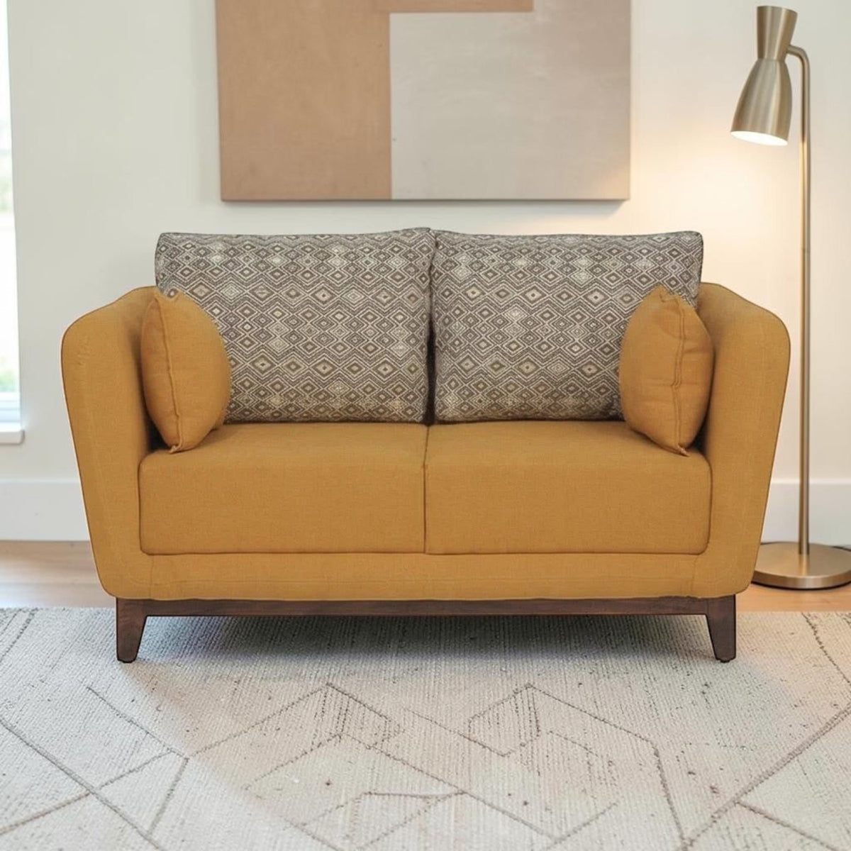 Homecrest modern 2-seater sofa in mustard fabric with patterned back cushions and solid wood base in a living room