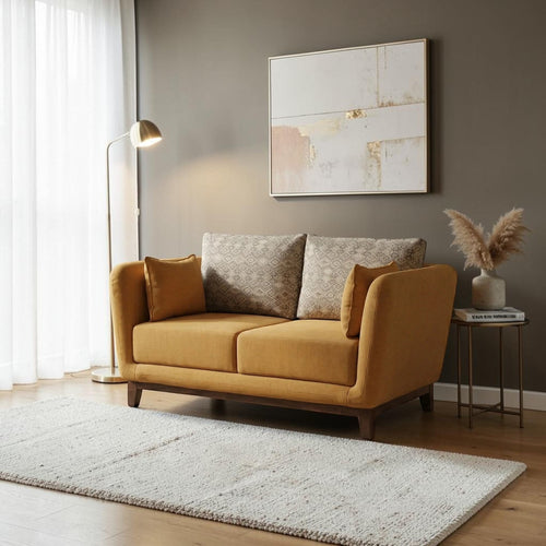 Homecrest modern 2-seater sofa in mustard fabric with patterned back cushions and a solid wood base in a living room.