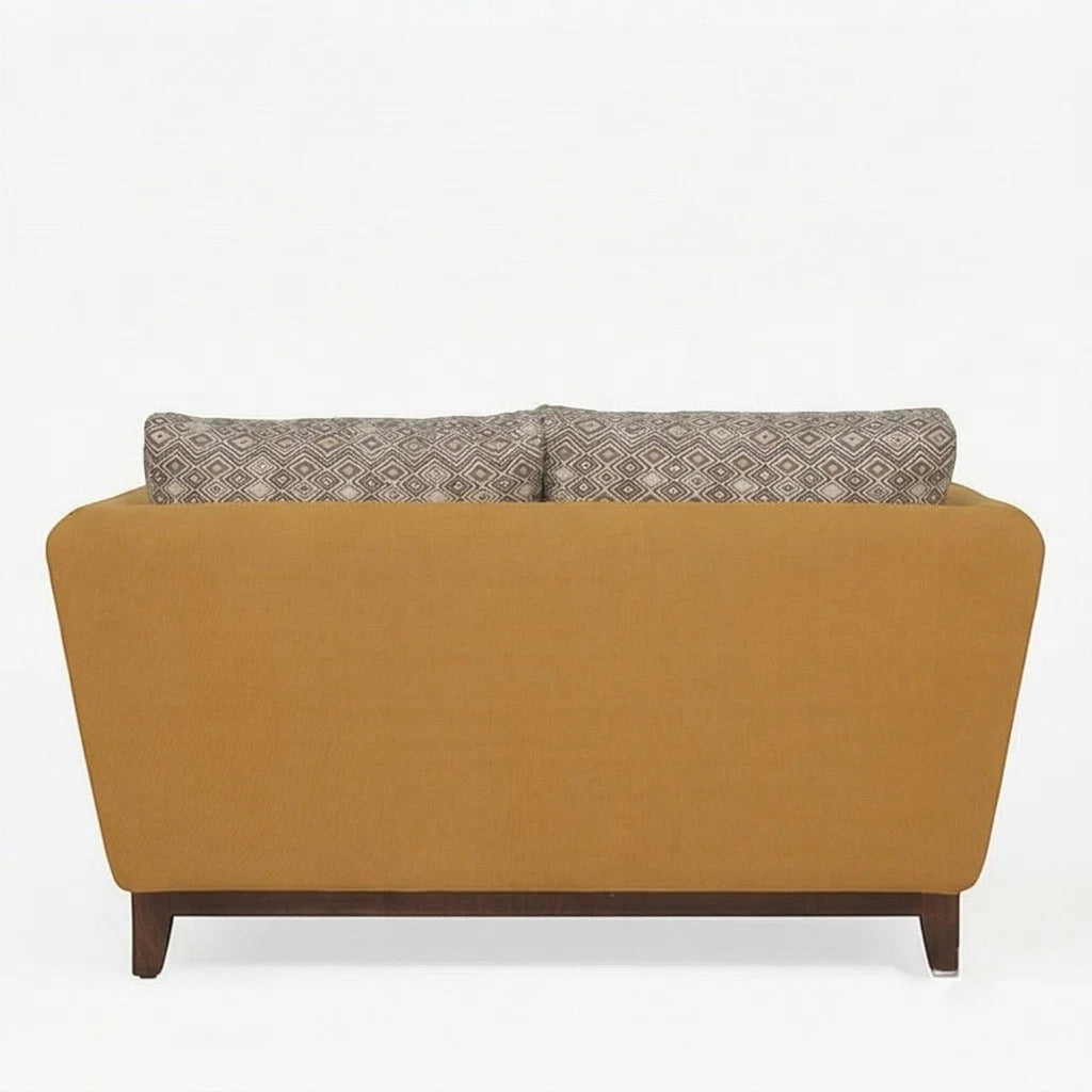 Homecrest 2-seater sofa in mustard fabric with a solid wood base and patterned back cushions, back view.
