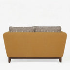 Homecrest 2-seater sofa in mustard fabric with a solid wood base and patterned back cushions, back view.
