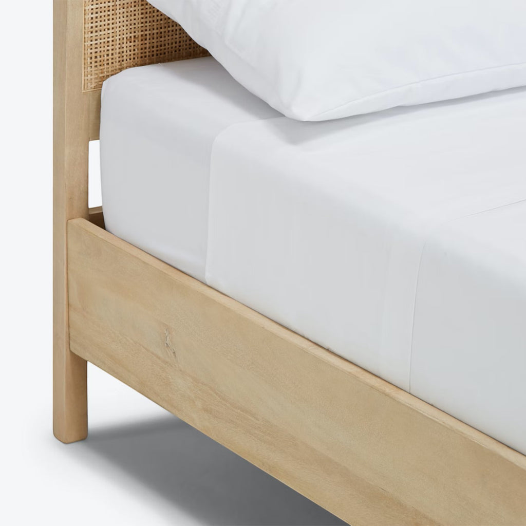 Homecrest natural mango wood bed frame with a woven rattan headboard and white bedding