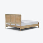 Homecrest natural mango wood bed frame with a woven rattan headboard viewed from the back corner