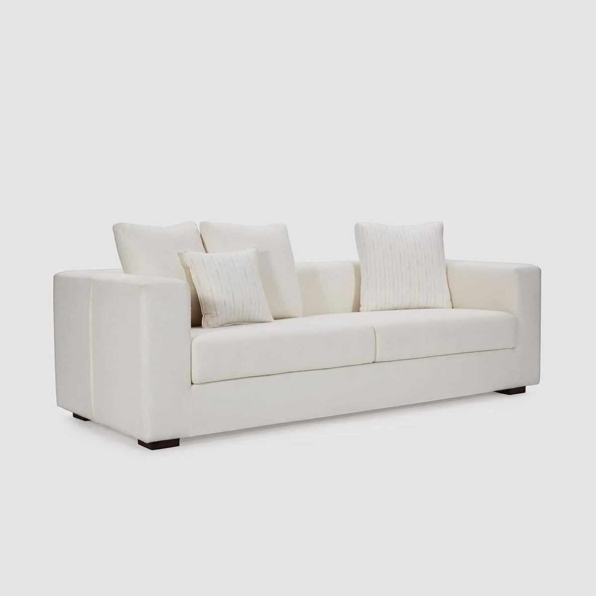 Homecrest Nesta low-profile deep-seat sofa in cream fabric with broad arms and matching decorative cushions