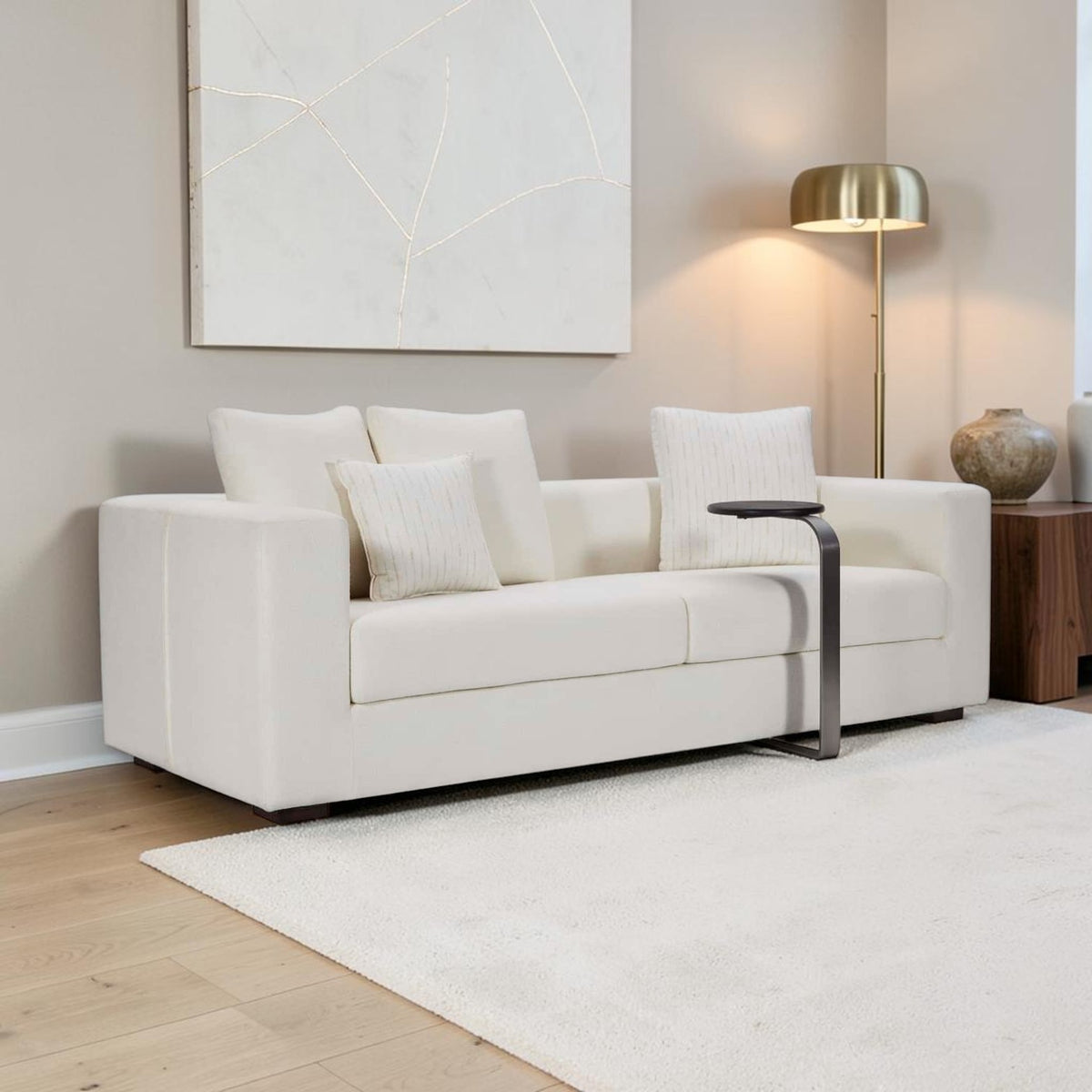 Homecrest Nesta low-profile cream sofa with deep seating, broad arms, and decorative cushions in a modern living room.