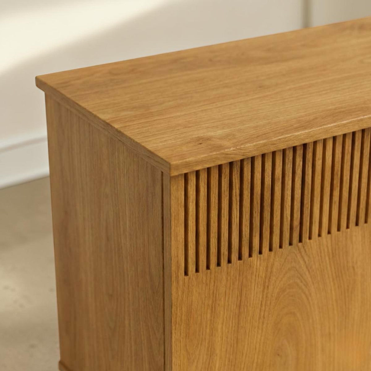 Homecrest Novar media cabinet in warm golden oak wood featuring signature vertical slatted door panels