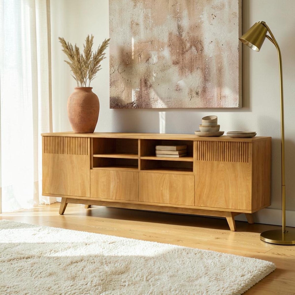 Homecrest Novar media cabinet in warm oak wood with slatted doors and open shelving in a sunlit living room.