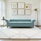 Homecrest Oakley Chesterfield sofa in light blue velvet with button tufting and nailhead trim in a modern living room.