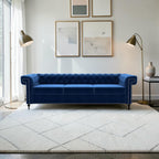 Homecrest Oakley three-seater Chesterfield sofa in deep indigo blue velvet with button tufting and nailhead trim.