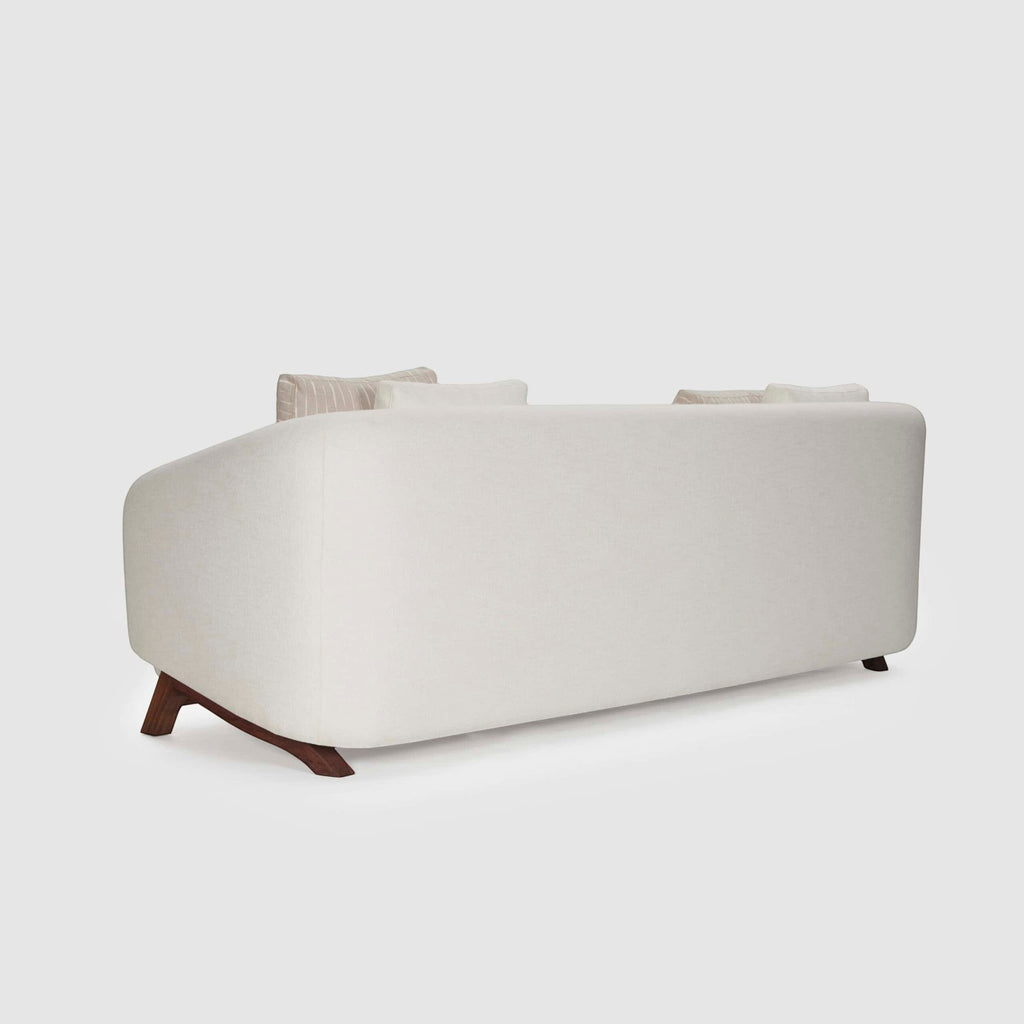 Homecrest Orbell wrap-arm curved sofa in cream fabric with sculptural dark teak wood legs, back view.