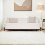 Homecrest Orbell wrap-arm curved sofa in cream upholstery with sculptural teak wood legs in a modern living room.