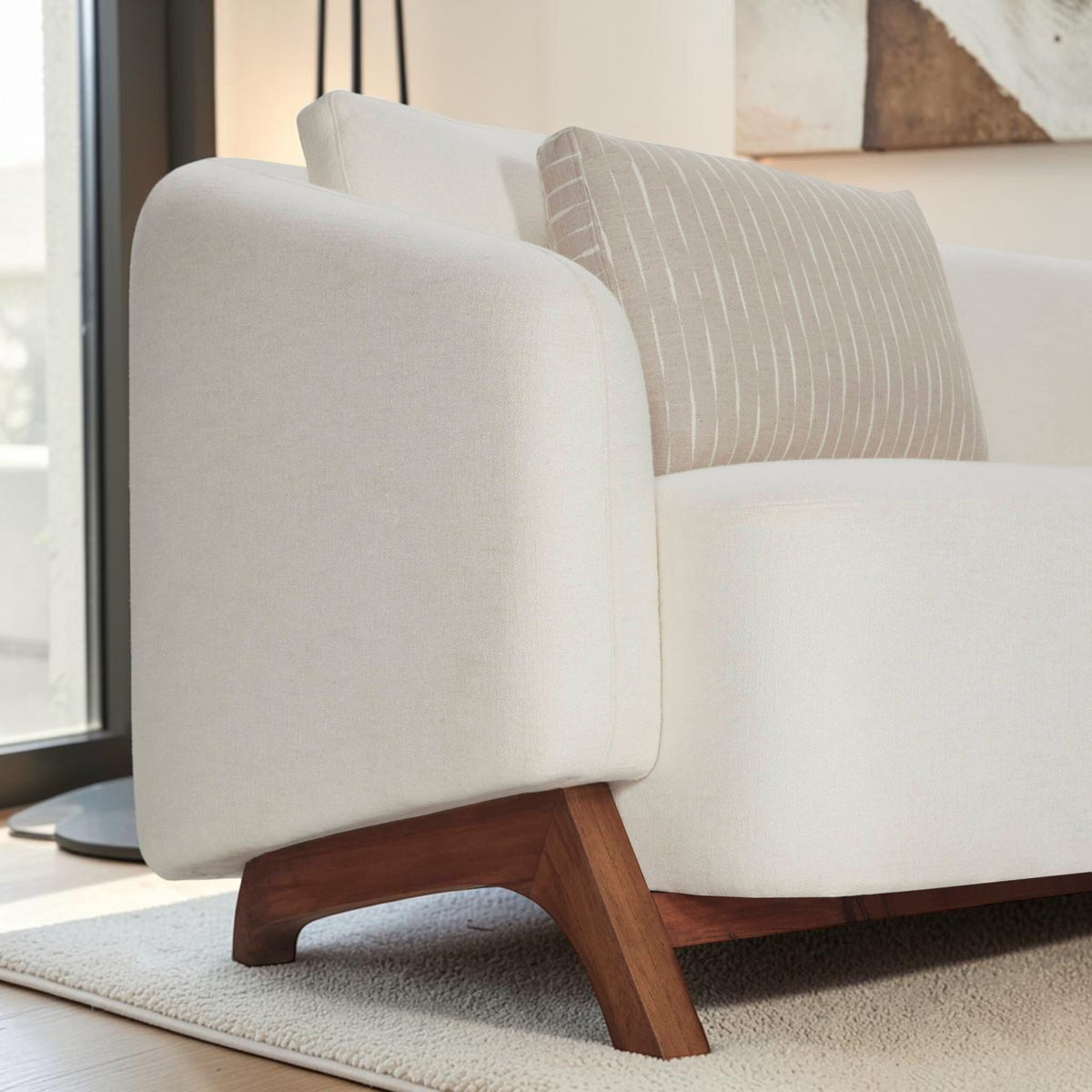 Homecrest Orbell curved sofa in cream fabric with wrap-around arms and sculptural teak wood legs