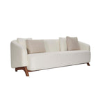 Homecrest Orbell wrap-arm curved sofa in cream fabric with sculptural teak wood legs and decorative accent cushions.