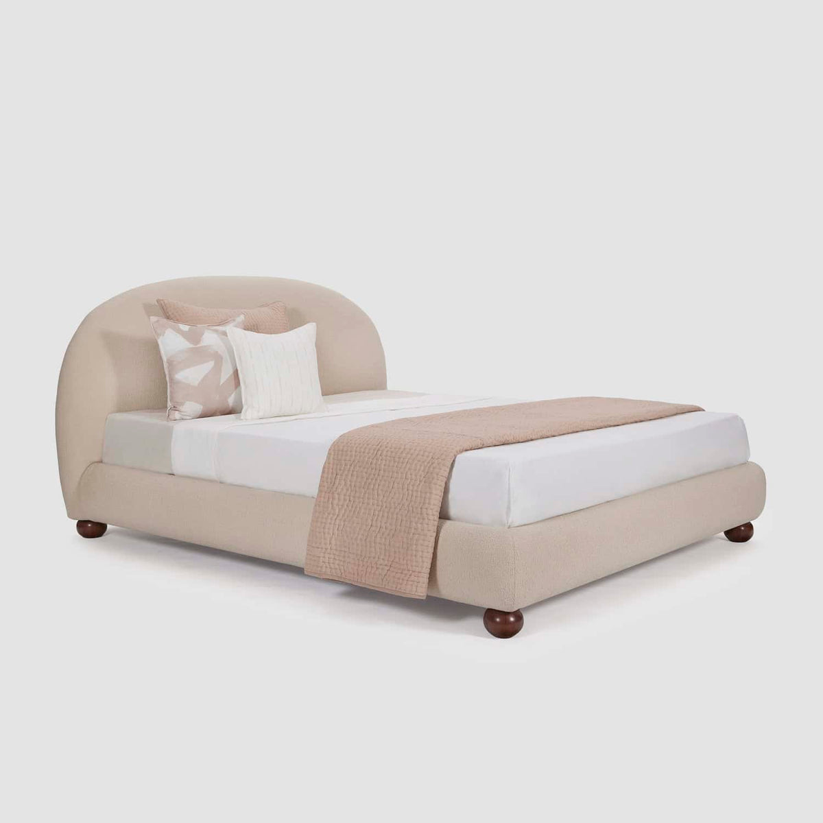 Homecrest Penhurst teakwood bed with a plush curved upholstered headboard and low profile frame on wooden feet