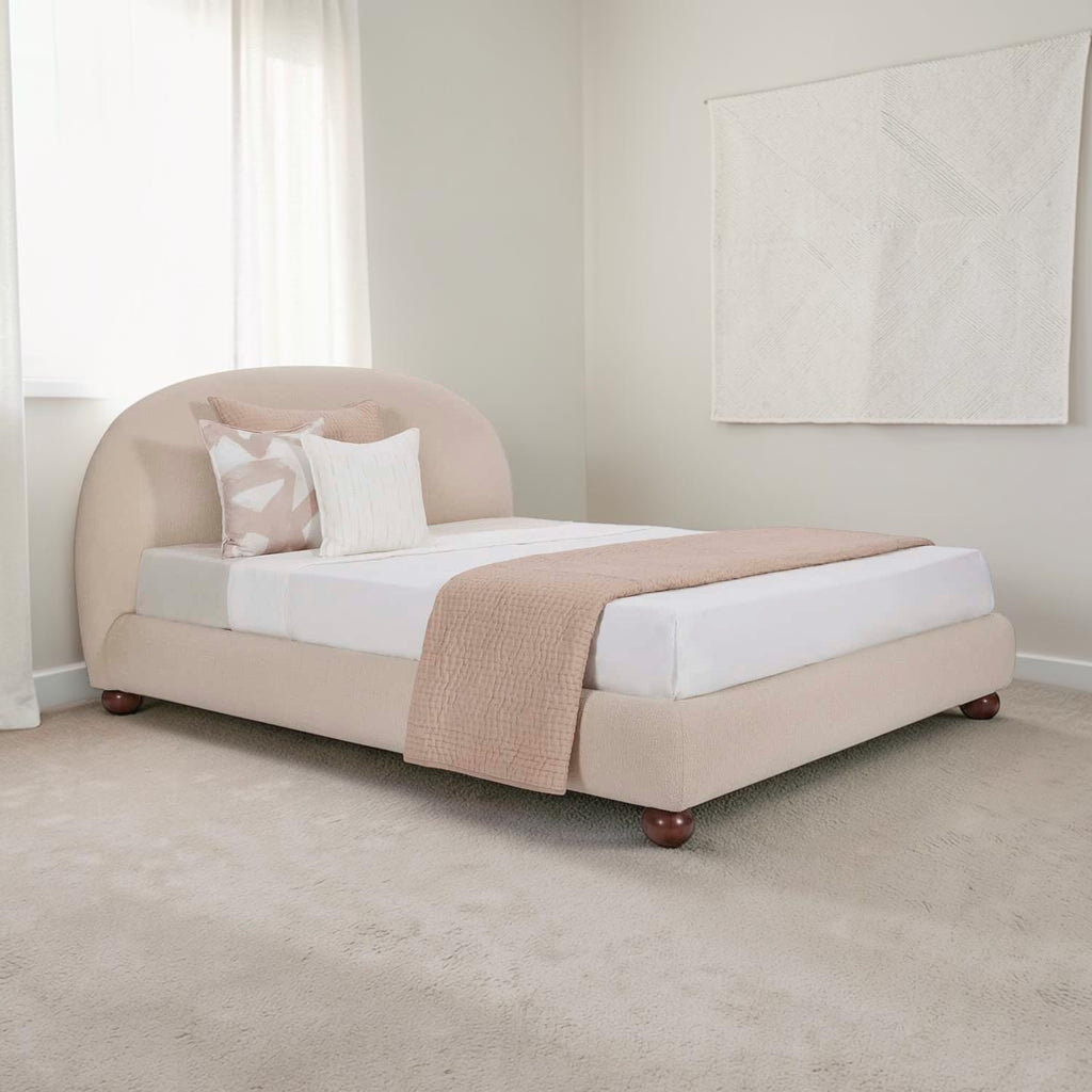 Homecrest Penhurst teakwood bed with a curved upholstered headboard and low profile frame in a neutral beige fabric.
