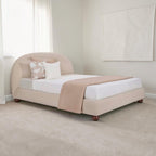 Homecrest Penhurst teakwood bed with a curved upholstered headboard and low profile frame in a neutral beige fabric.