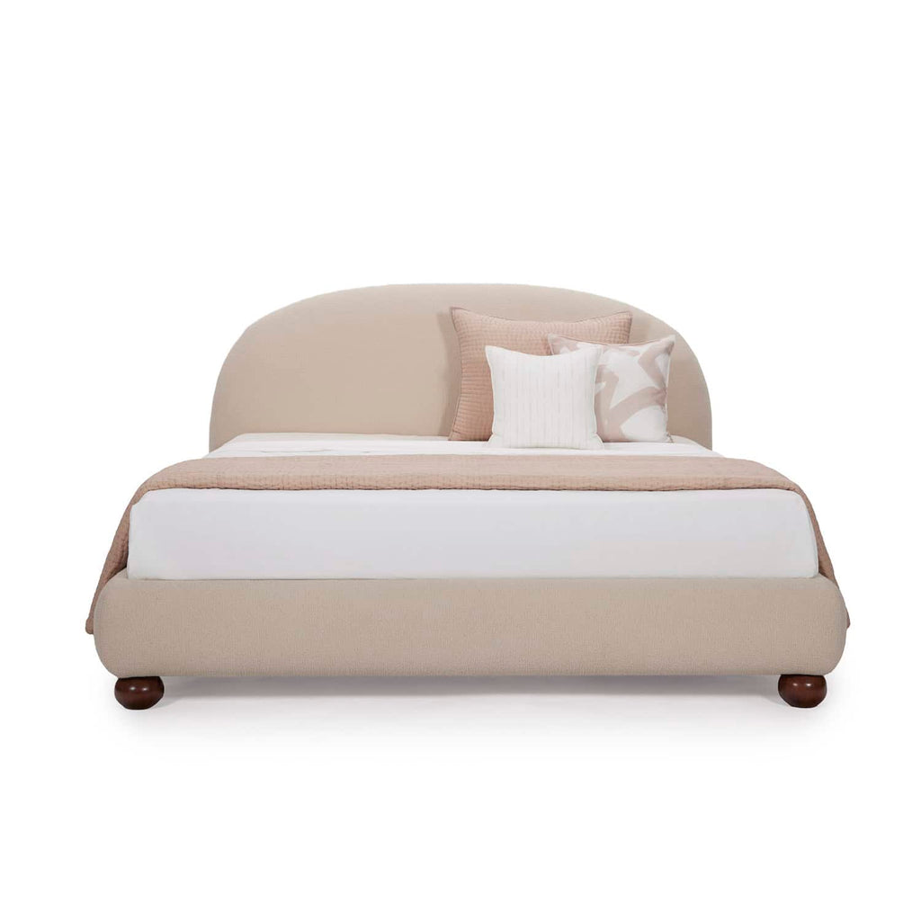 Homecrest Penhurst teakwood bed with a curved upholstered headboard and low profile frame in a neutral beige fabric.