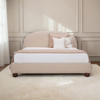 Homecrest Penhurst teakwood bed with a curved upholstered headboard and low profile frame in a neutral beige fabric.