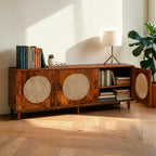 Homecrest Petra three-door media cabinet in honey-finished sheesham wood with circular cane rattan door inserts.