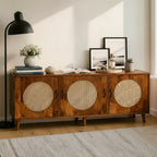 Homecrest Petra three-door media cabinet in honey-finished solid sheesham wood with circular cane rattan door inserts.
