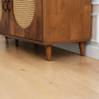 Homecrest Petra three-door media cabinet in honey-finished solid sheesham wood with circular cane rattan door inserts.
