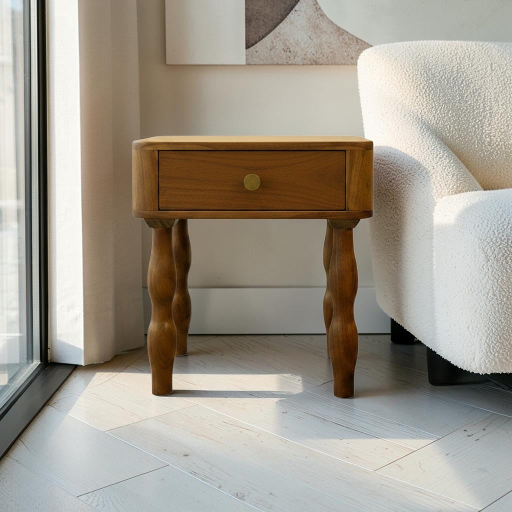Homecrest Ravenna bedside table in natural acacia wood with a single drawer and unique curvy legs in a coastal room.