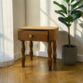 Homecrest Ravenna bedside table in natural solid acacia wood with a single drawer and curvy legs in a coastal room.
