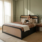 Homecrest rattan storage platform bed with dark wood frame and cane panels, featuring a woman reading in bed.