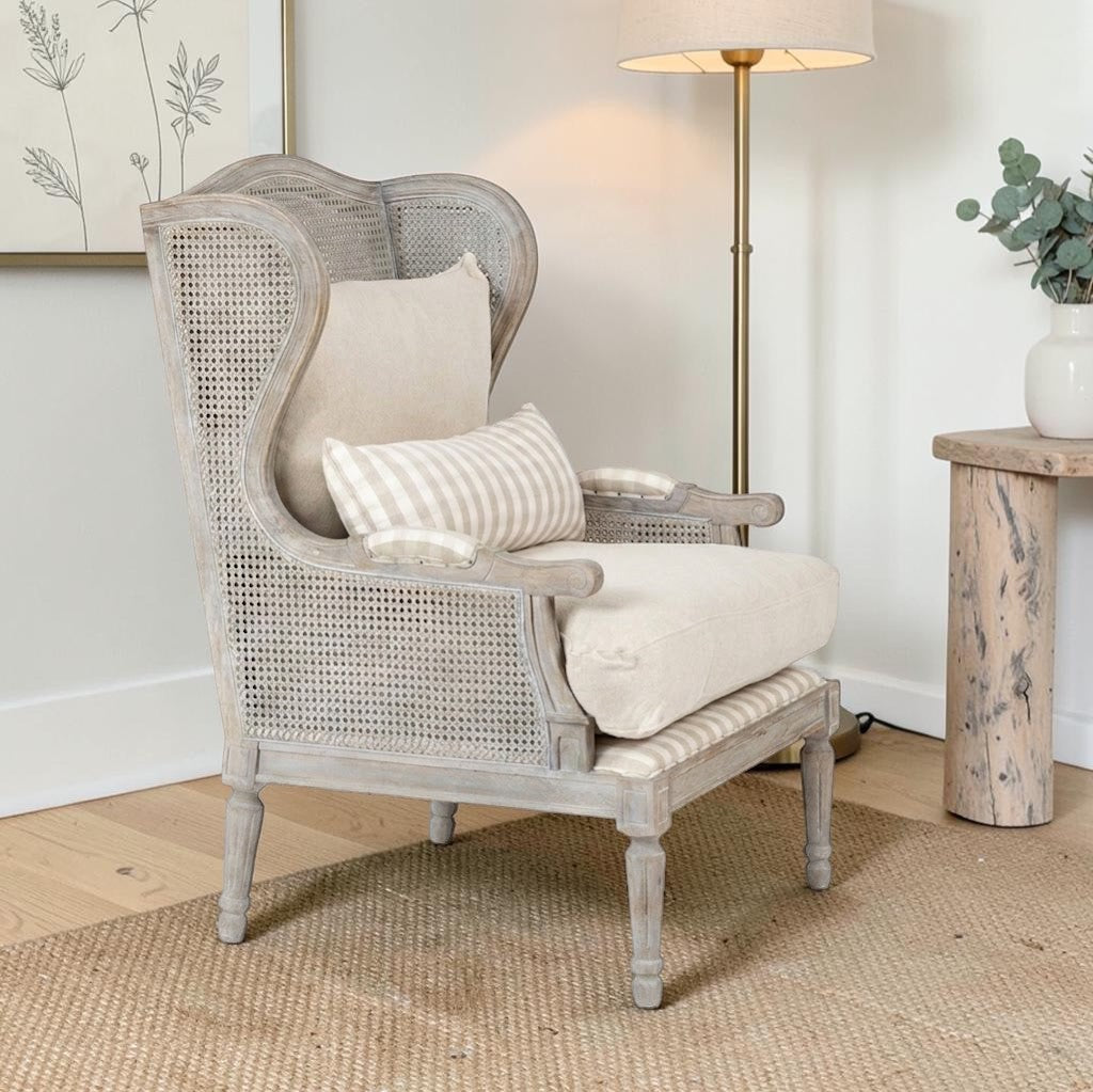 Homecrest Ridlington grey solid wood armchair with rattan side panels and beige upholstered cushions in a living room