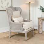 Homecrest Ridlington grey solid wood armchair with rattan side panels and beige upholstered cushions in a living room