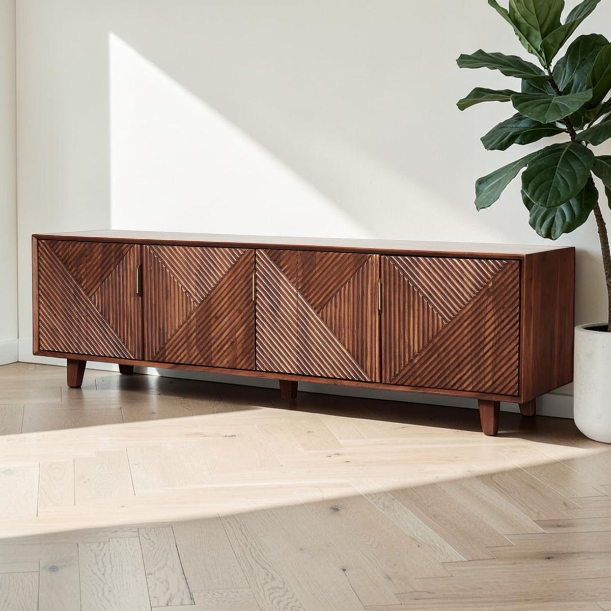 Homecrest Sabine media cabinet in solid sheesham wood with four fluted doors and gold-toned handles in a bright room.