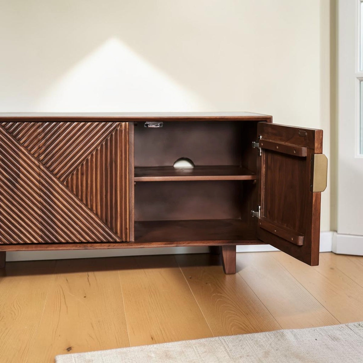 Homecrest Sabine fluted media cabinet in walnut sheesham wood with gold-toned handles and open storage compartment.