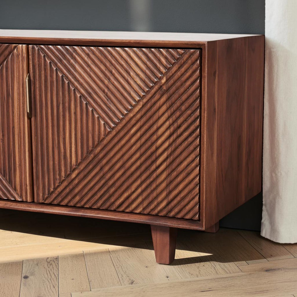 Homecrest Sabine media cabinet in walnut sheesham wood with fluted geometric door fronts and gold-toned handles.
