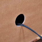 Homecrest Sabine media cabinet back panel featuring a circular cable management hole with a black power cord