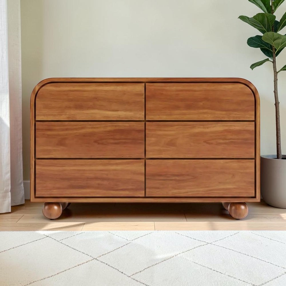 Homecrest Roswell 6-drawer dresser in warm brown acacia wood with a rounded frame and spherical feet.