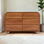 Homecrest Roswell 6-drawer dresser in warm brown acacia wood with a rounded frame and spherical feet.