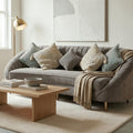 Homecrest Calvert sofa in grey velvet with curved backrest, decorative throw pillows, and a light beige throw blanket.