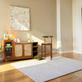 Homecrest Selby sideboard in medium teak with wicker doors, fluted glass cabinet, and open shelving in a living room.