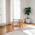 Homecrest Semley mid-century armchair in natural teak wood and hand-woven rattan wicker in a bright living room.