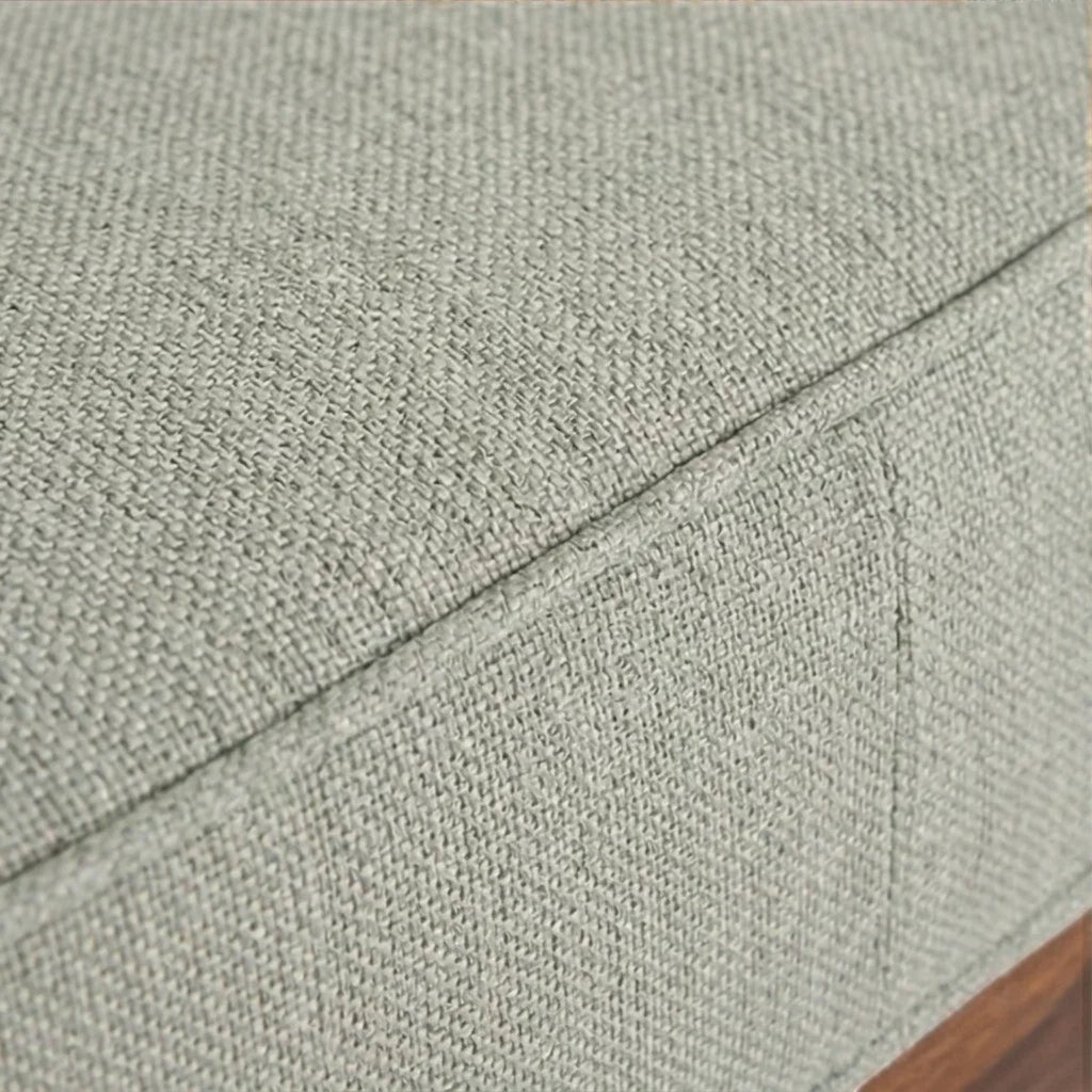 Close-up of Homecrest 2-seater sofa showing the textured light green fabric upholstery and piped cushion edges.