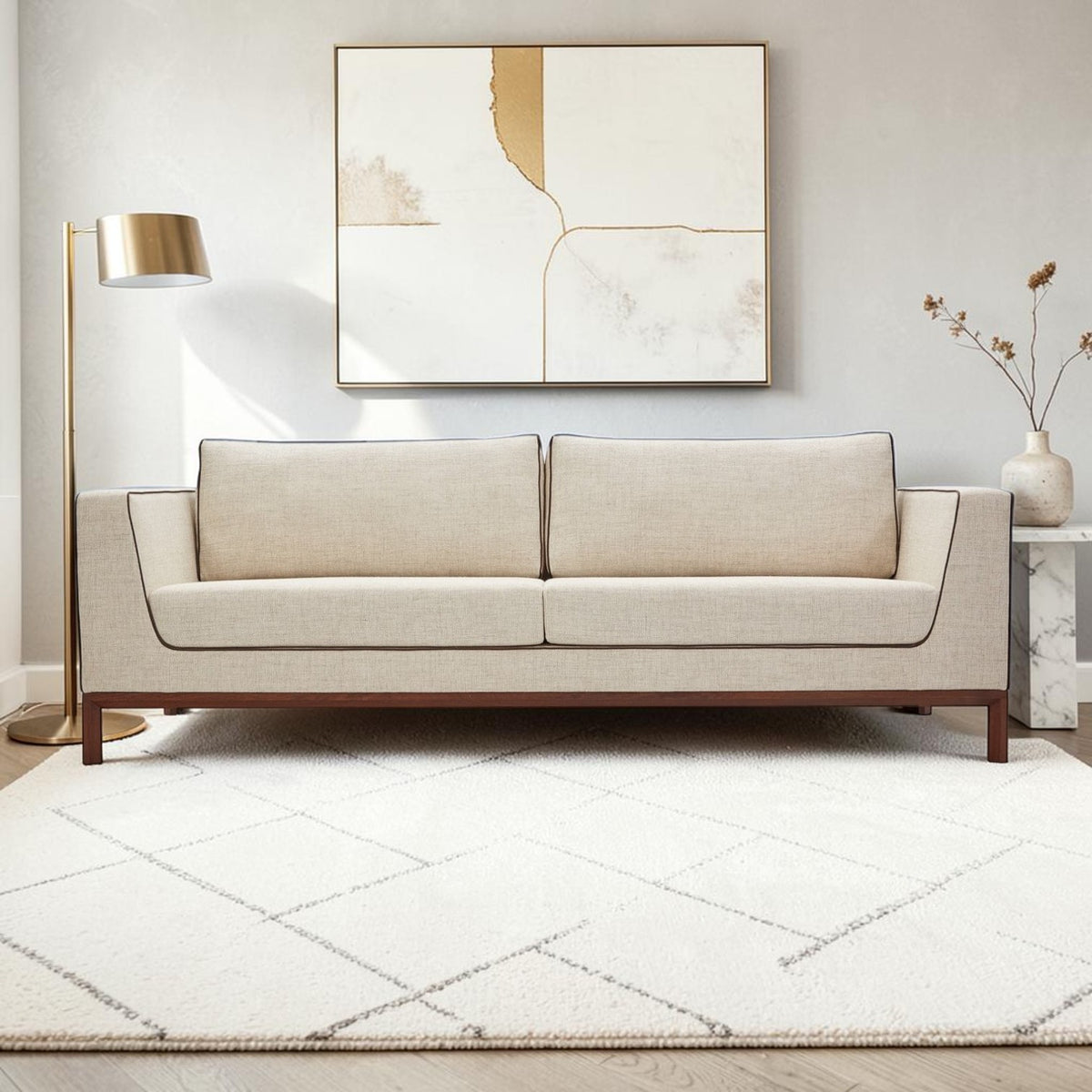Homecrest Solace deep-seat lounge sofa in ivory fabric with contrast piping on a teakwood base in a modern living room.