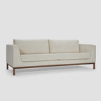 Homecrest Solace deep-seat lounge sofa in ivory fabric with contrast piping on a solid teakwood base frame.
