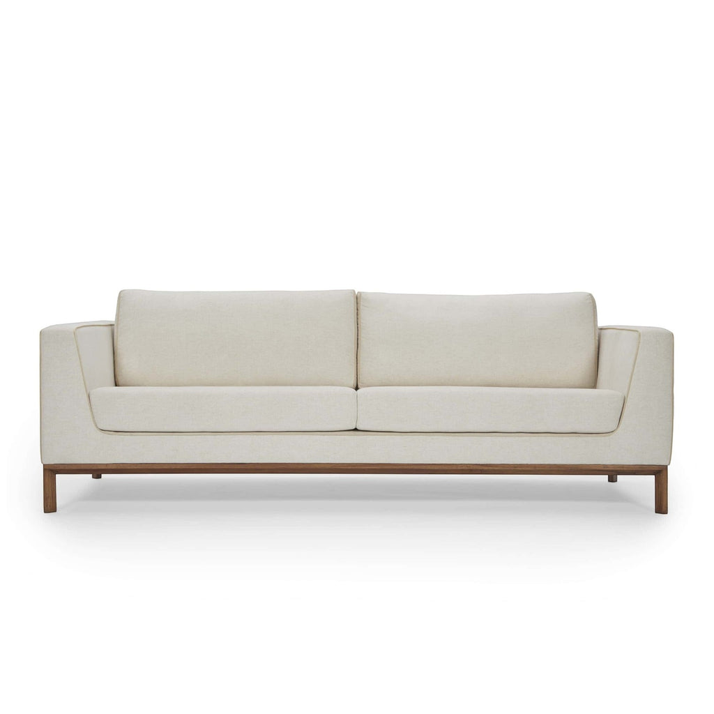Homecrest Solace deep-seat lounge sofa in ivory fabric with contrast piping on a handcrafted teakwood base frame.