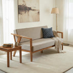 Homecrest 2-seater sofa with natural solid wood frame and beige fabric cushions in a minimalist living room setting.