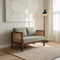 Homecrest 2-seater sofa with solid walnut wood frame, natural cane side panels, and sage green fabric cushions.