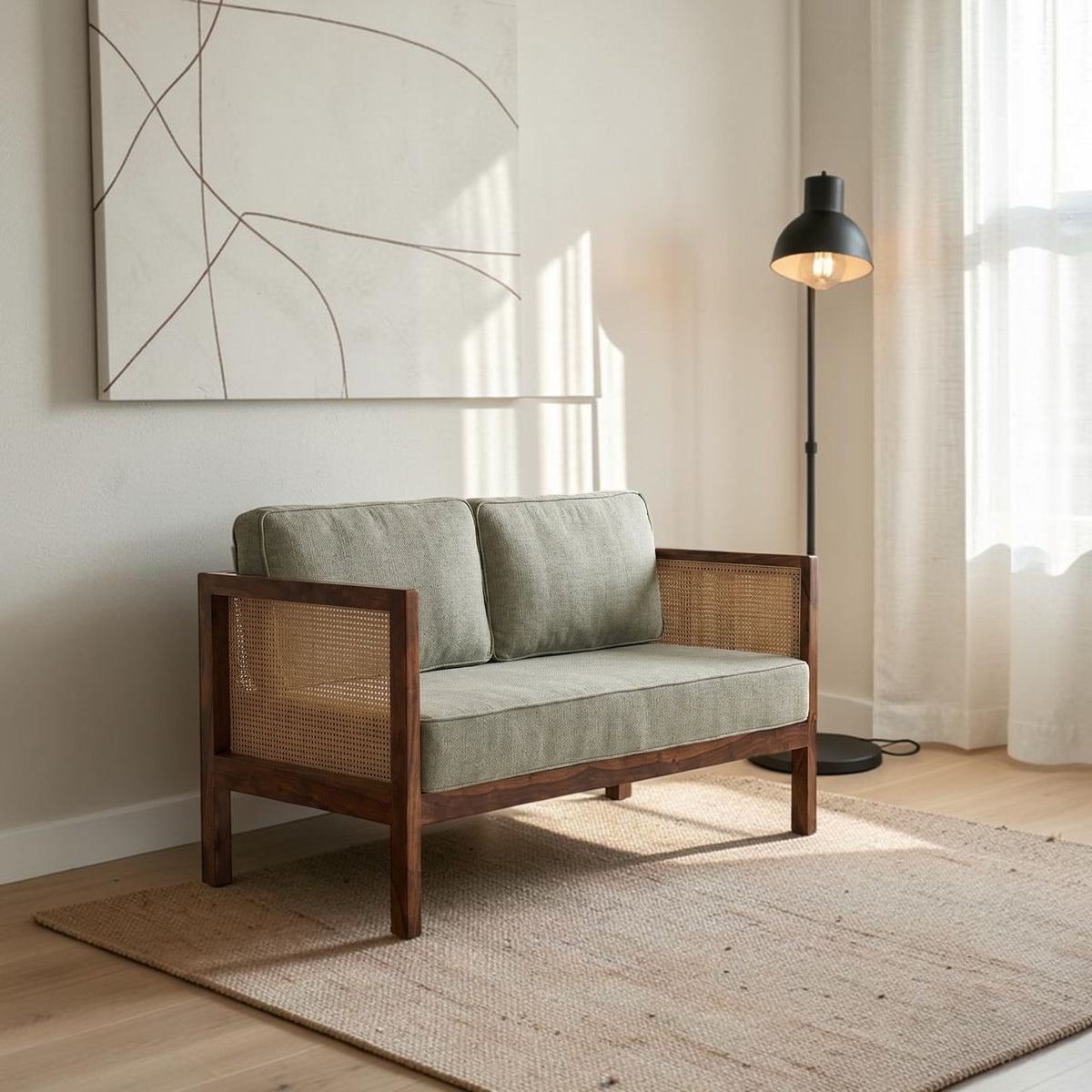 Homecrest 2-seater sofa with solid walnut wood frame, natural cane side panels, and sage green fabric cushions.