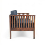 Homecrest contemporary solid wood sofa with dark grey cushions and elegant vertical slatted armrests, side view.
