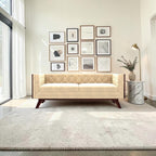 Homecrest Sturton Chesterfield sofa in beige velvet with tufted backrest and dark wooden legs in a bright living room.