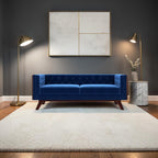 Homecrest Sturton velvet Chesterfield sofa in deep indigo blue with button tufting, set in a modern living room.