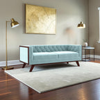 Homecrest Sturton velvet Chesterfield sofa in light blue with a dark wood frame and button-tufted back in a living room.