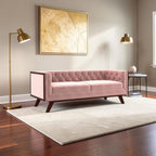 Homecrest Sturton velvet Chesterfield sofa in rose dust with button tufting and dark wooden legs in a modern living room